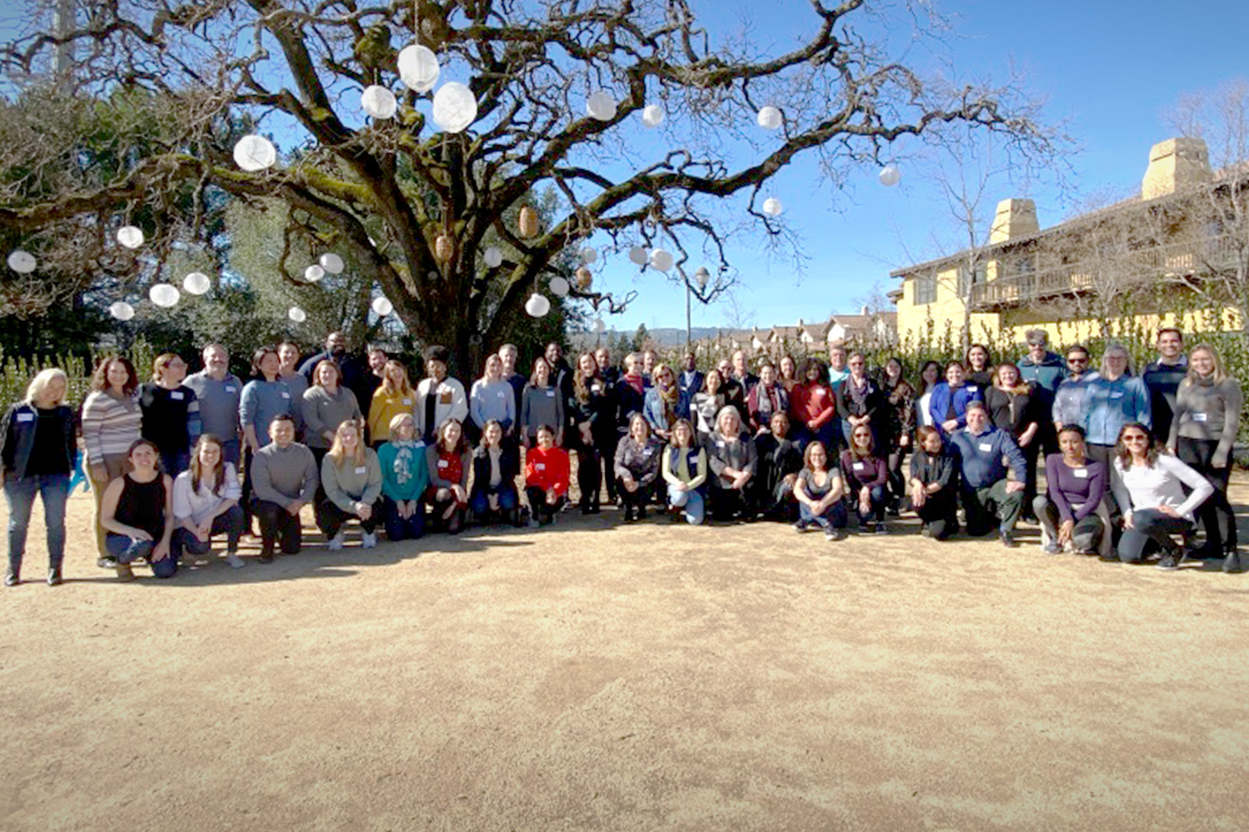 a group of people posing for a photo under a tree